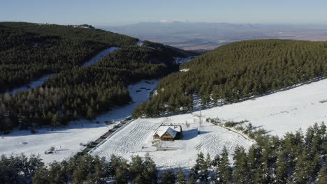 Serene-flight-over-a-deserted-cabin-in-an-empty-ski-resort-with-deep-snow