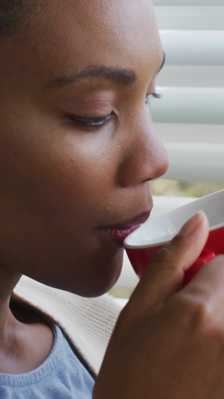 Vídeo vertical: Mulher com copo vermelho, ícones de CTA animados, fazendo-a levantar o copo e beber para promoção