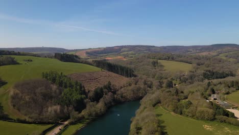 4K-flying-over-hawkridge-reservoir,-drone-moving-forward-over-the-water-with-the-trees-and-the-blue-sky-in-the-background,-60fps