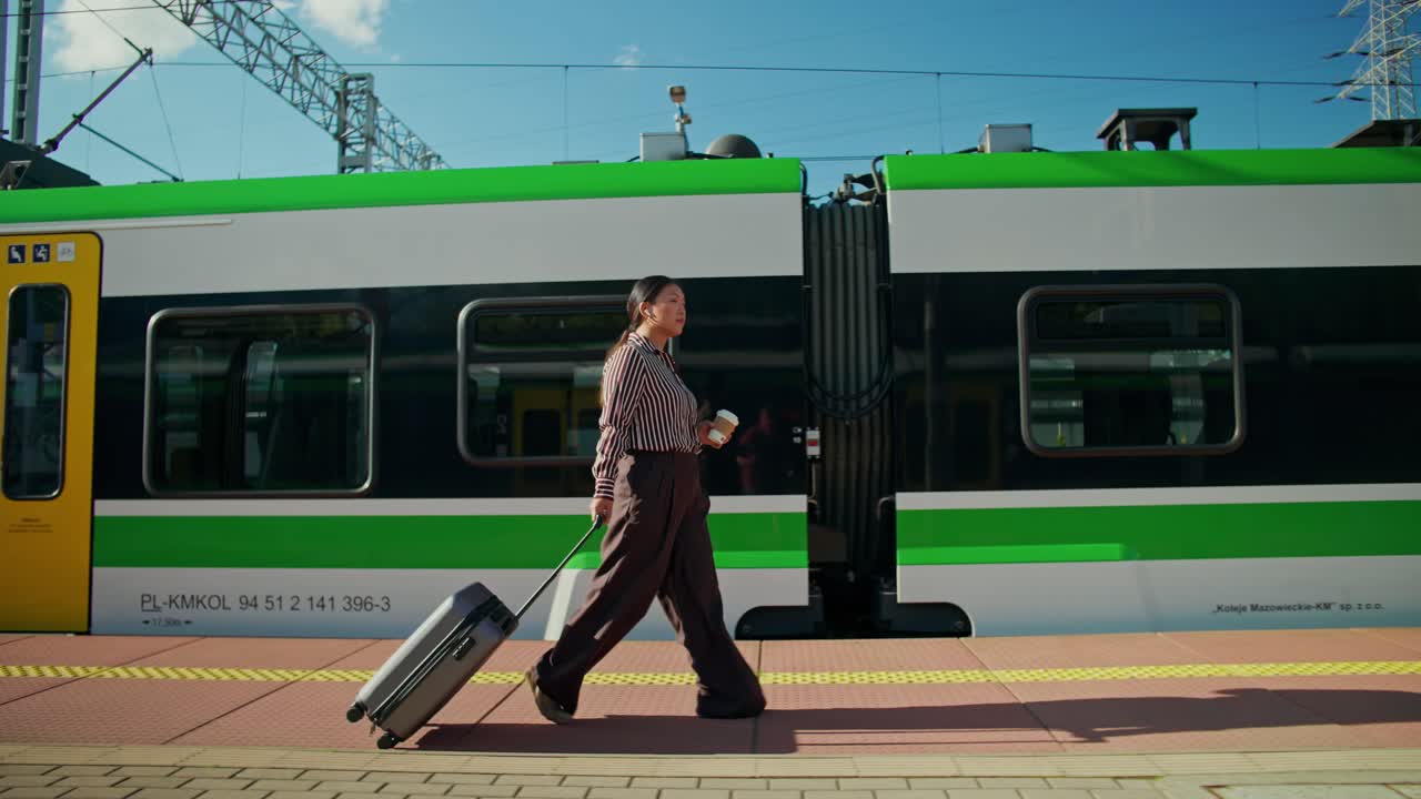駅で荷物を持って旅行する女性