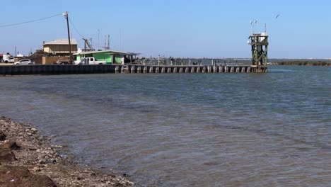 Vista-De-La-Tienda-De-Cebos,-La-Rampa-Para-Botes-Y-El-Embarcadero-Bajo-La-Calzada-Jfk-En-La-Isla-Del-Padre-Norte,-Texas