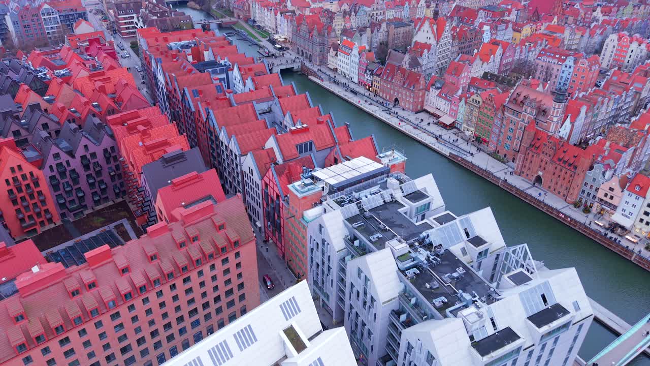 New Motlawa riverfront commercial buildings, hotel complex, apartments on Granary Island with rotatable footbridge connecting old town Gdansk old town tourist landmarks, Europe, Aerial revealing shot