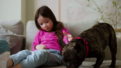 girl petting dog at home