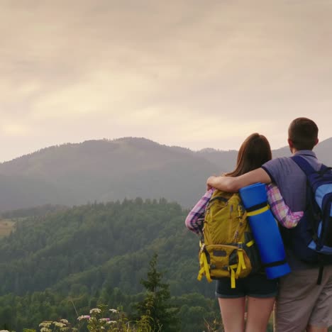 crane shot: a young couple of tourists with backpacks look up at the sky on an airplane