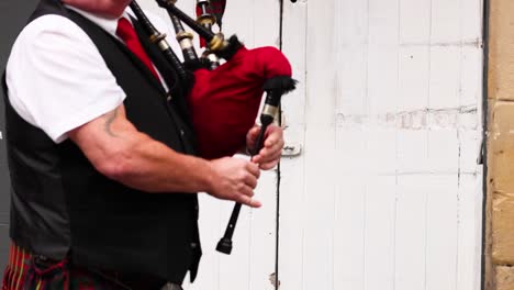 bagpiper playing in traditional attire