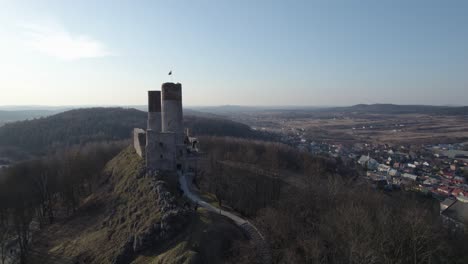 A-rearward-aerial-drone-shot-of-the-Chęciny-Royal-Castle-from-its-side-entrance-with-footpath