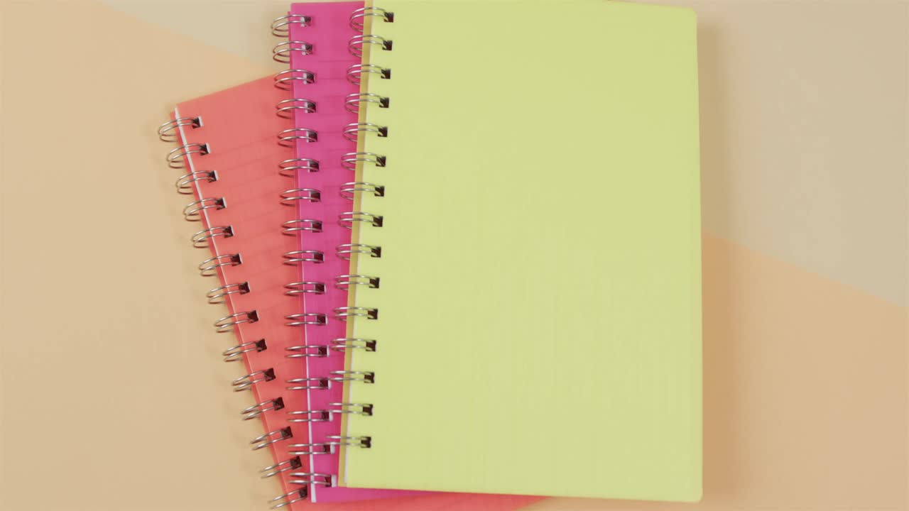 tres cuadernos con espacio de encuadernación y copia en fondo naranja