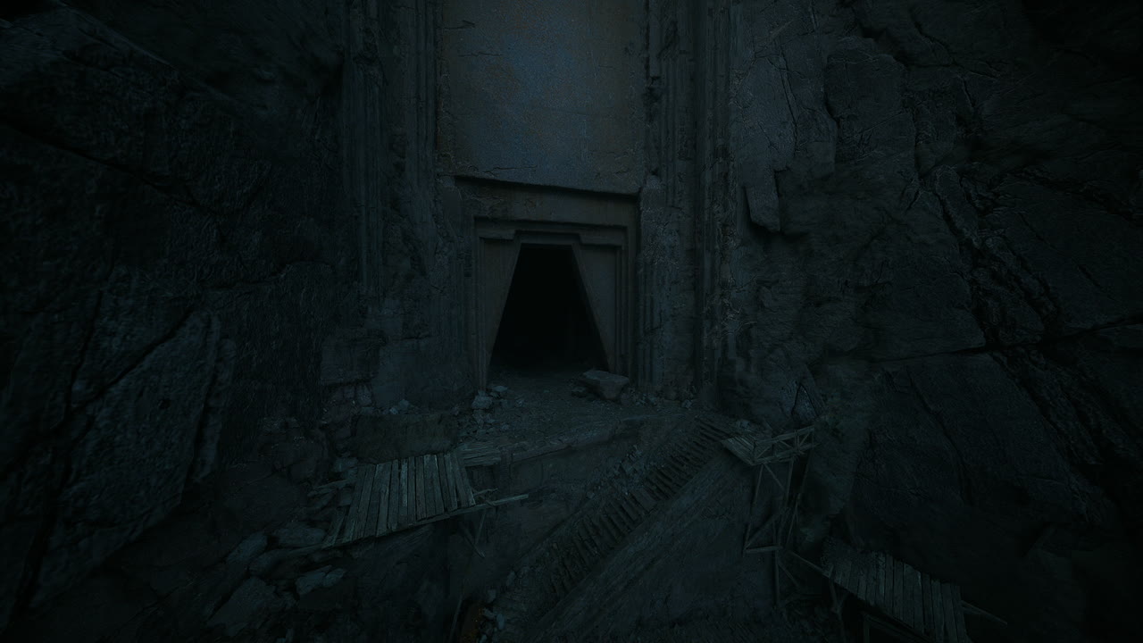 antigua entrada a una cueva oscura rodeada de escarpadas paredes de piedra