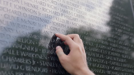 a person rubs their hands on a military personnel tribute