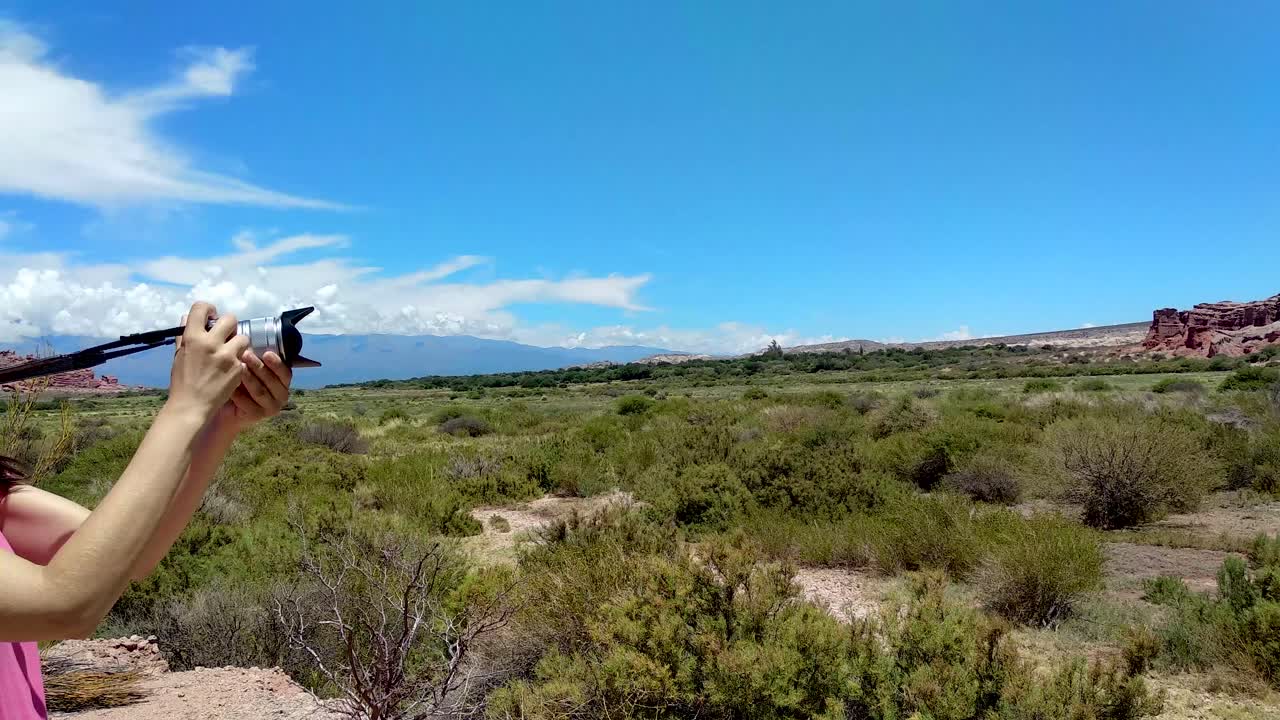 una joven toma fotos y videos de la quebrada de cafayate en argentina