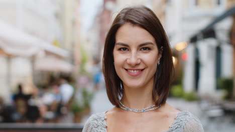 happy young woman smiling looking away dreaming, resting, good news, feel satisfied in city street