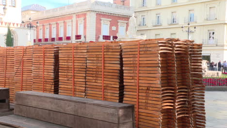 stacked wooden chairs in a city square