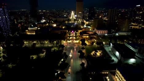 vista aérea de tirana por la noche, con luces de bulevar, tráfico y coches de la ciudad creando un espectacular tapiz urbano