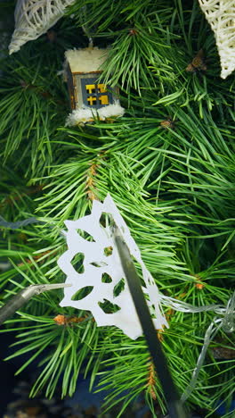 christmas tree and metal cyborg arms. robotic equipment for decorating new year tree with paper snowflake. intelligent machinery. vertical video