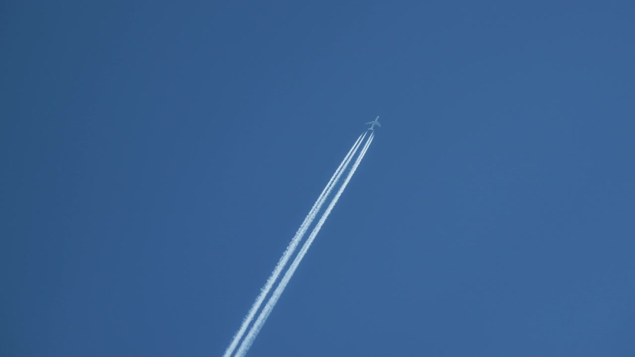 Avion volant haut dans le ciel bleu laissant des traînées