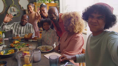 happy family smiling and waving on camera at home dinner party