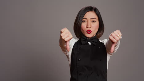 asian restaurant hostess showing thumbs down and dislike sign