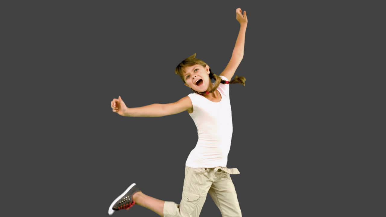 una niña saltando en la pantalla gris