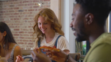 grupo multicultural de amigos disfrutando de pizza para llevar en casa juntos