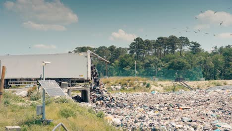 wide angle view of a semi-trailer, creating a mountain of garbage