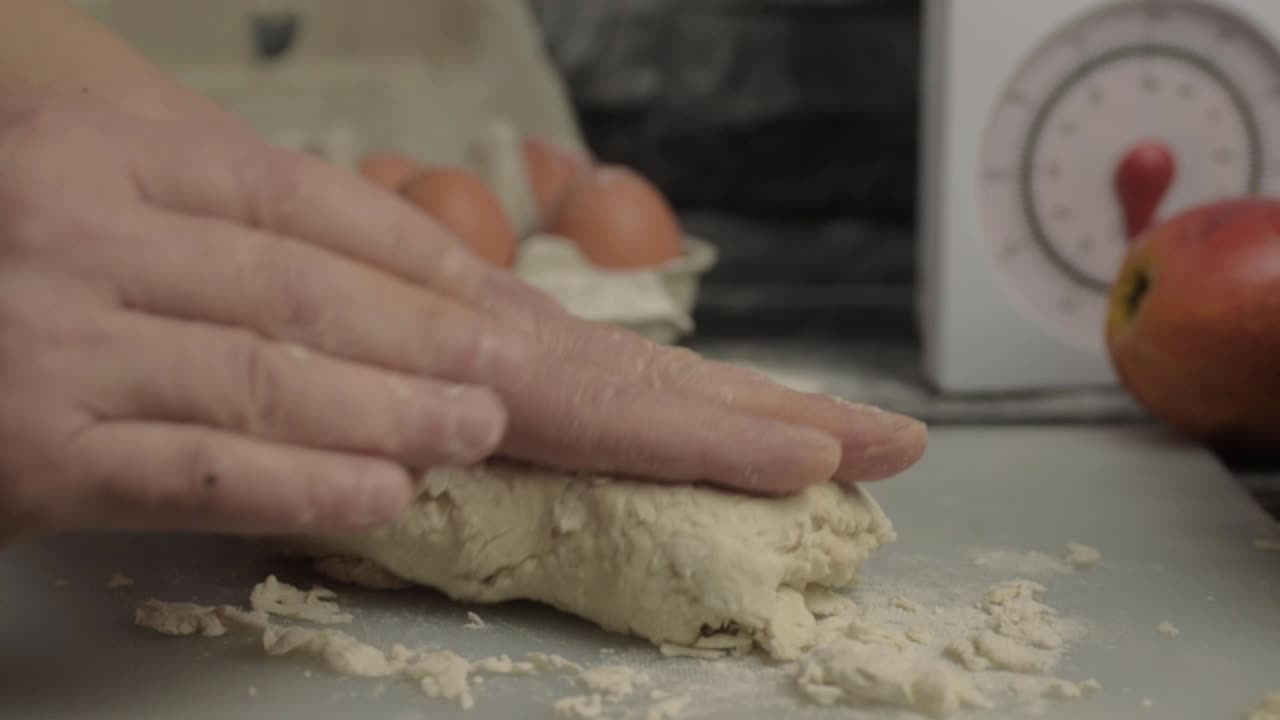 Hands kneading pastry dough in kitchen close up shot