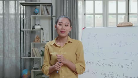 asian female teacher with marker pen teaching math at home