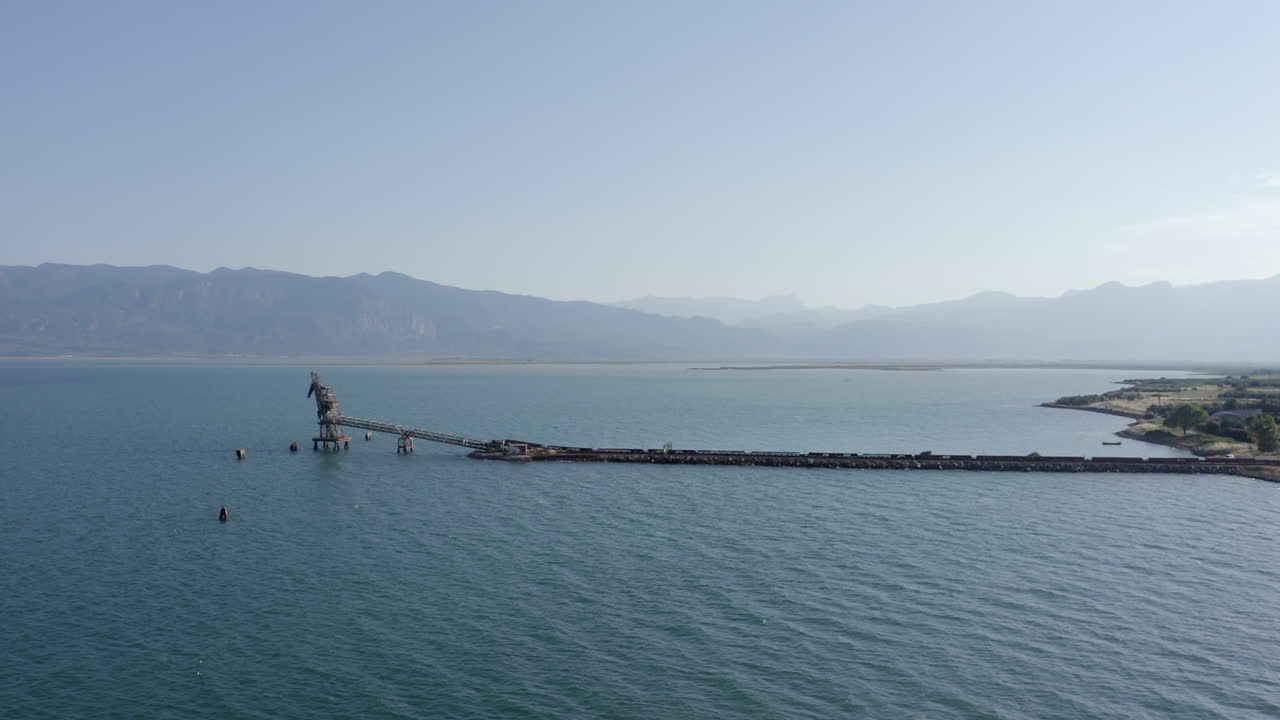 긴 컨베이어 피어는 해상 운송을 위해 축적 광석을 정박에 가져옵니다.