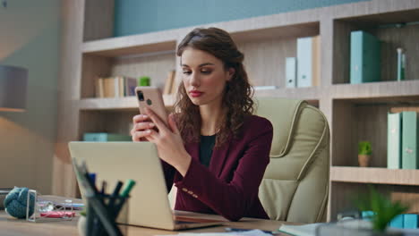 stressed businesswoman reading sms at workplace. concerned woman think problem