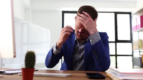 businessman suffering from stress and eye strain at work