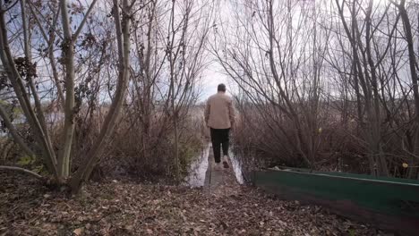 man walks on wooden pier in a autumn day