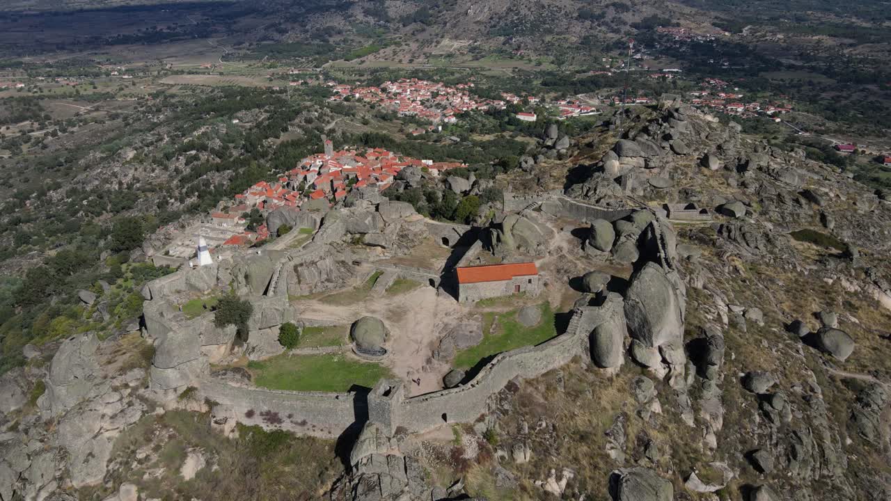 la cámara de un dron captura una vista de cerca de los cantos rodados y las rocas que rodean el castillo de monsanto