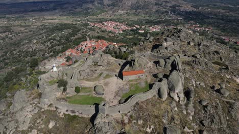 drone camera captures a close up view of the boulders and rocks surrounding monsanto castle