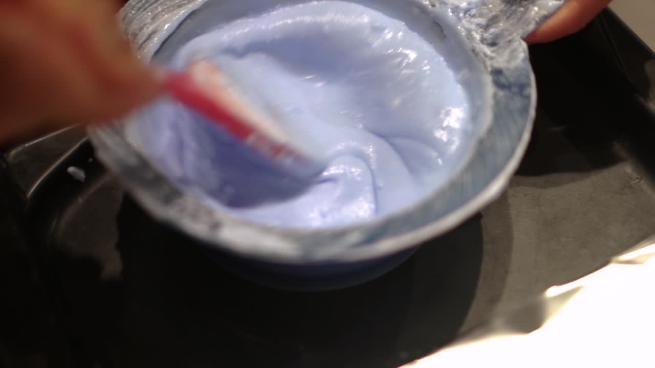 el tinte para el cabello se mezcla con un pincel