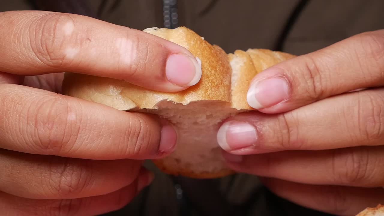 Hands Breaking a Piece of Fresh Bread