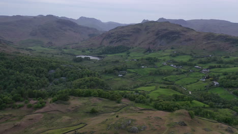vuelo aéreo al atardecer sobre el pueblo de little langdale desde holme fell