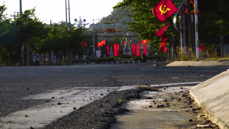 communist flag waving in wind on city street in vietnam