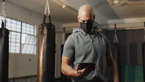 Colocar-A-Un-Hombre-Caucásico-Con-Mascarilla-Usando-Una-Tableta-Digital-En-El-Gimnasio.