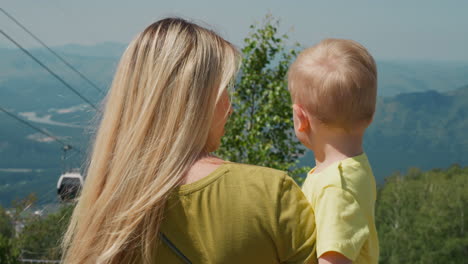 mother holds little son and points forward at highland hills