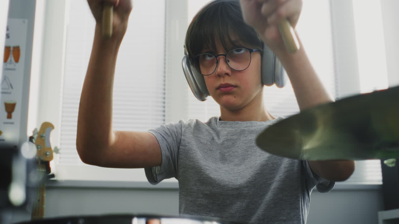 Boy playing drums with headphones