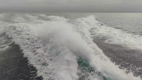 Estela-De-Agua-Vista-Desde-Atrás-De-Un-Bote-De-Motor-En-Movimiento-Rápido-En-Un-Día-De-Cielo-Despejado,-Mar-Azul,-Superficie-De-Agua