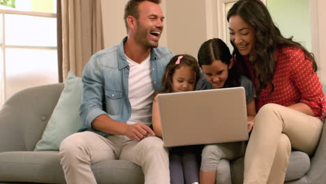 happy family using laptop on the sofa