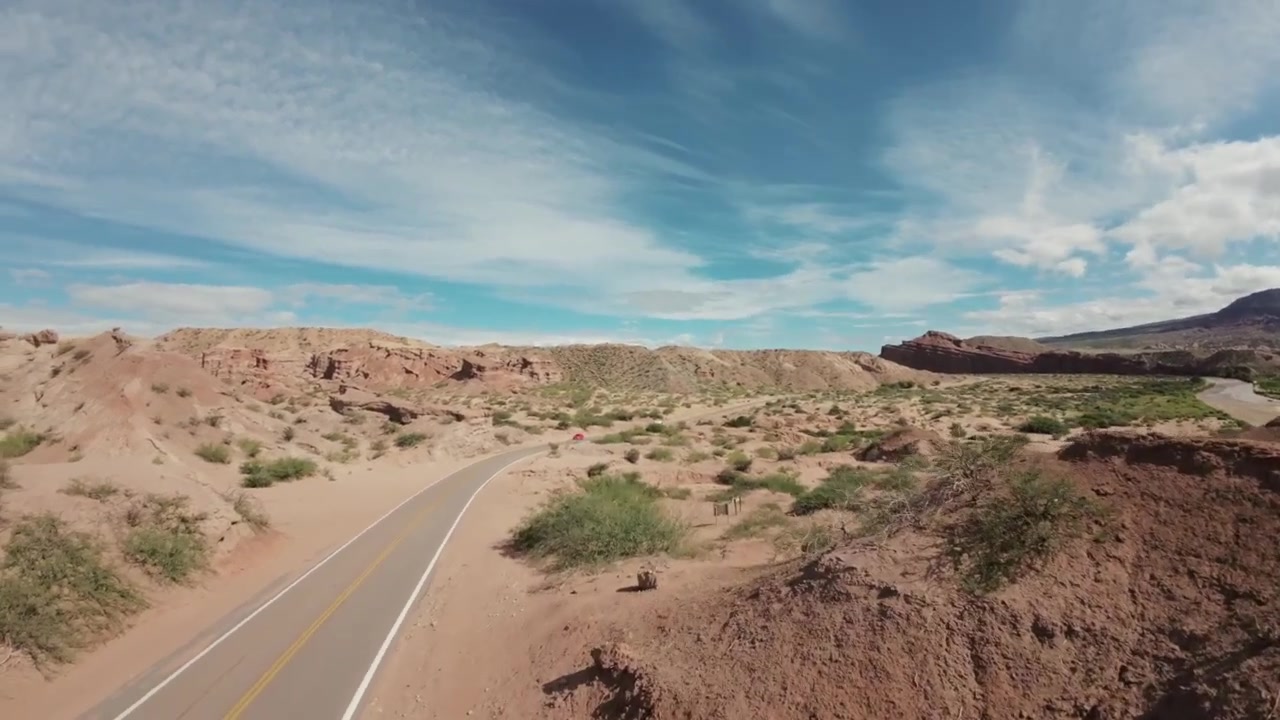 Widok z drona FPV na utwardzoną trasę w suchym krajobrazie Quebrada las Conchas, Cafayate. Salta, Argentyna. 4k.