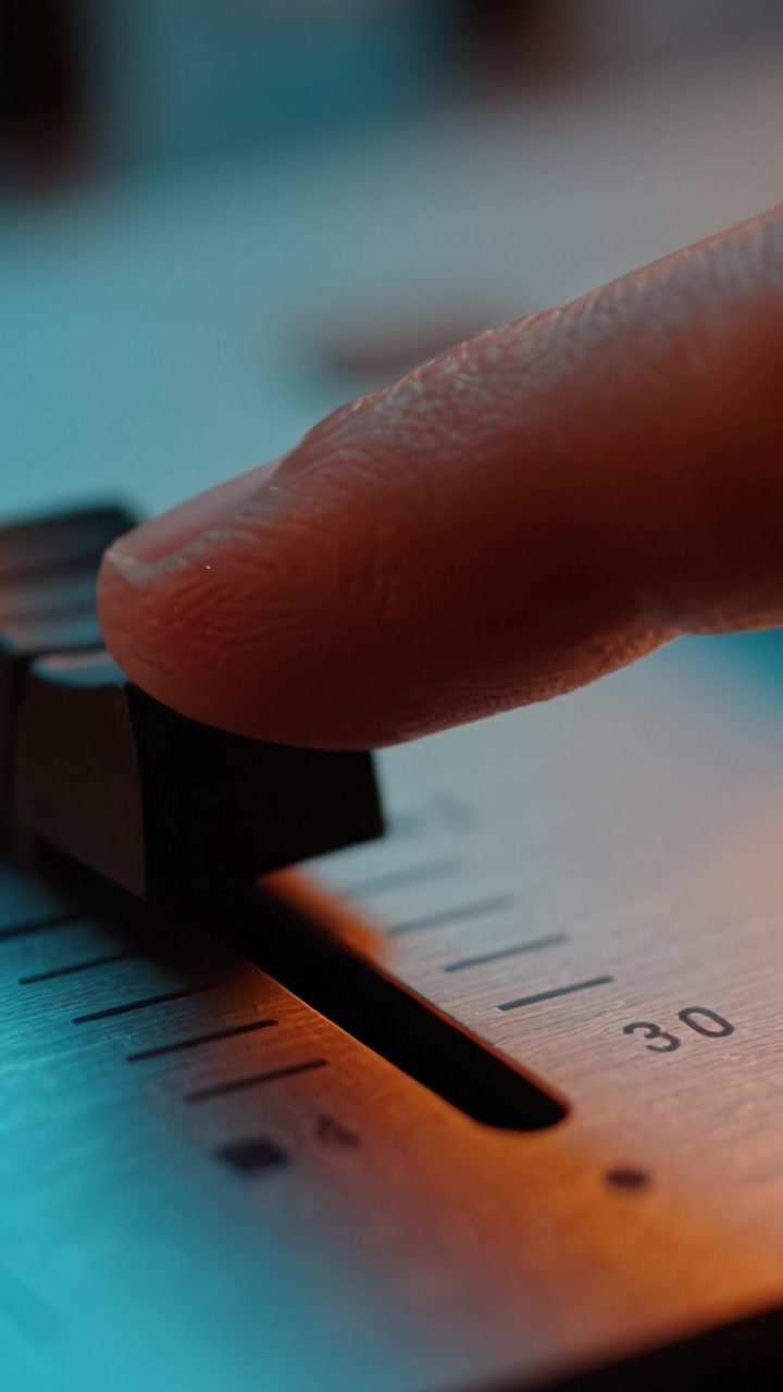 Close-Up of a Music Mixing Console Slider with Warm Lighting Capturing the Essence of Sound Engineering and Audio Mixing Techniques in a Professional Studio Environment