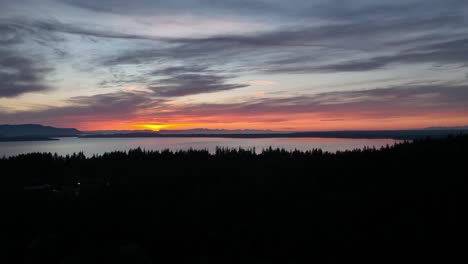 Toma-Aérea-Que-Se-Inclina-Hacia-Arriba-Desde-El-Campus-De-La-Universidad-De-Washington-Occidental-Para-Revelar-La-Puesta-De-Sol-Sobre-La-Bahía-De-Bellingham