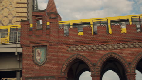 u-bahn urban metro train passing over a red brick bridge in berlin, germany