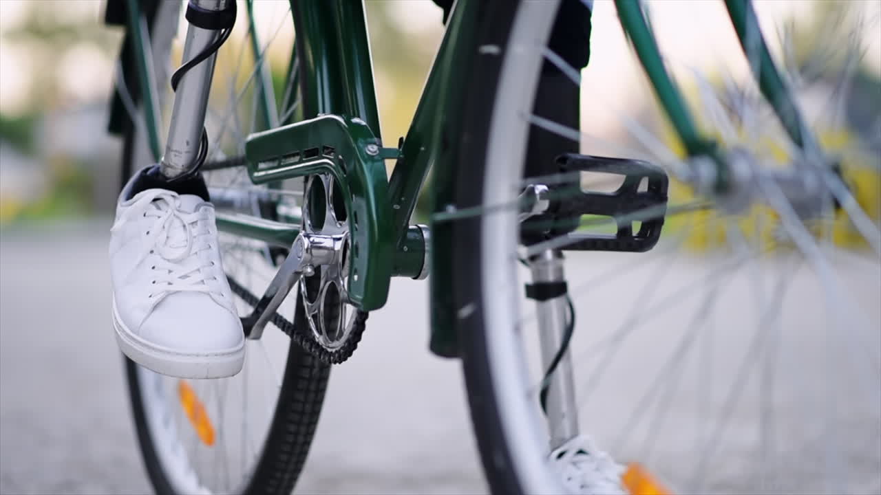 Slow motion view of a man with prosthetic legs. Sitting on his bike