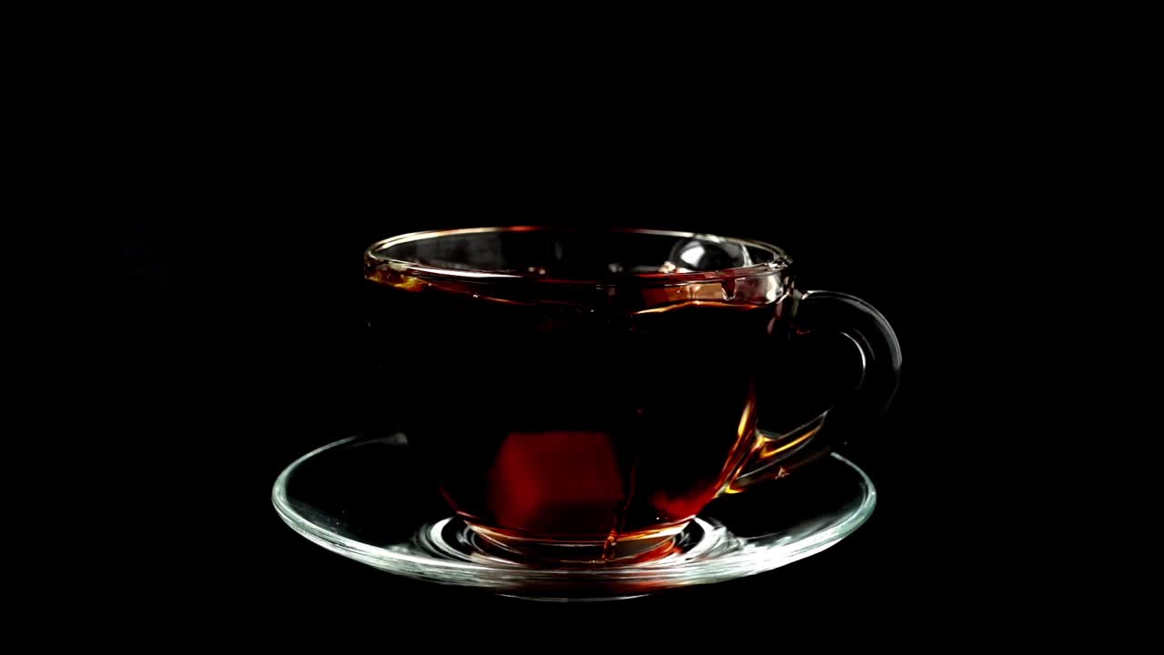 Zucchero cade in una tazza con tè. Movimento rallentato.