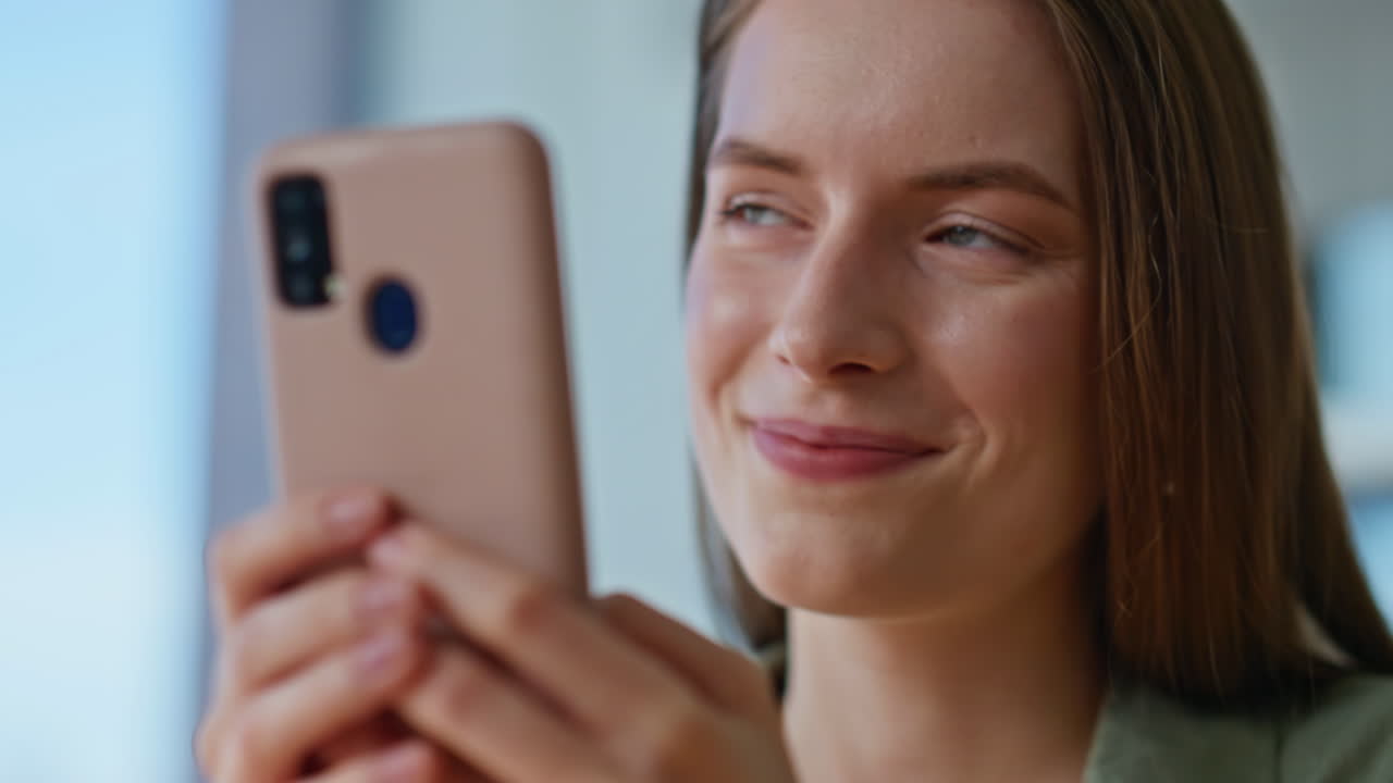 Pretty lady texting smartphone relaxing in apartment closeup. Happy brunette