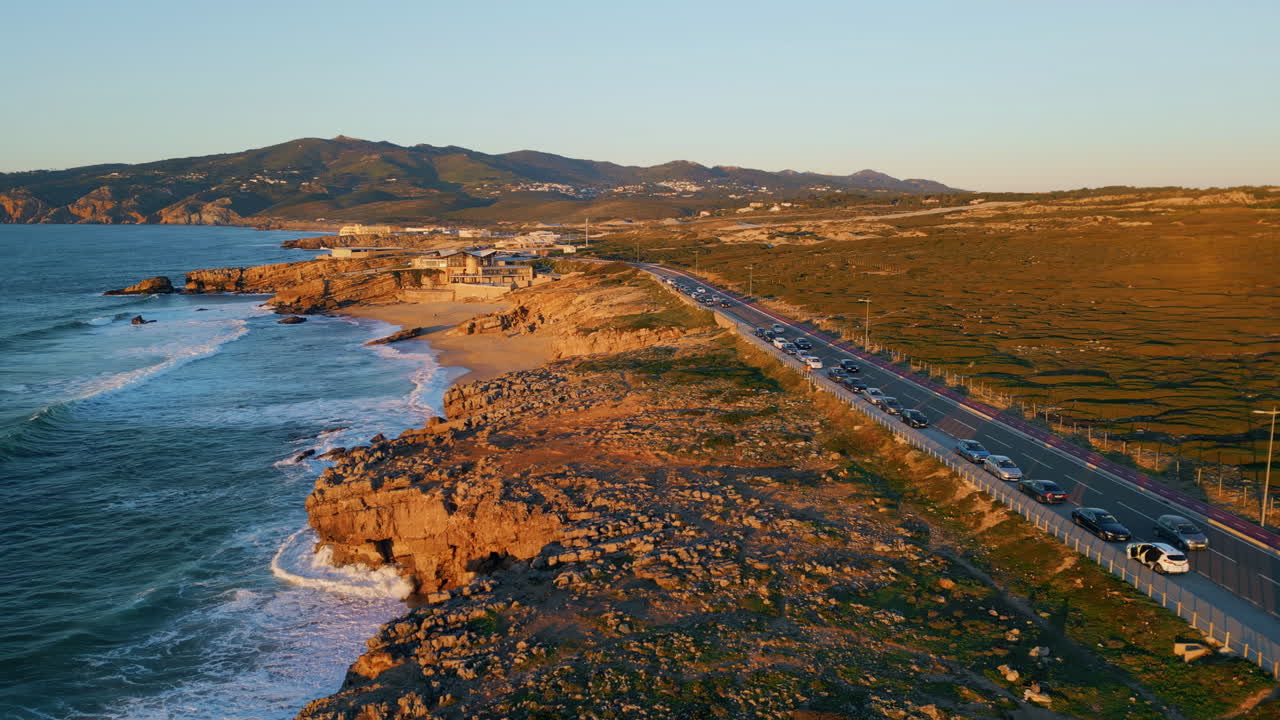 황금빛의 빛에서 해안 도로를 운전하는 자동차. 해변을 따라 도로