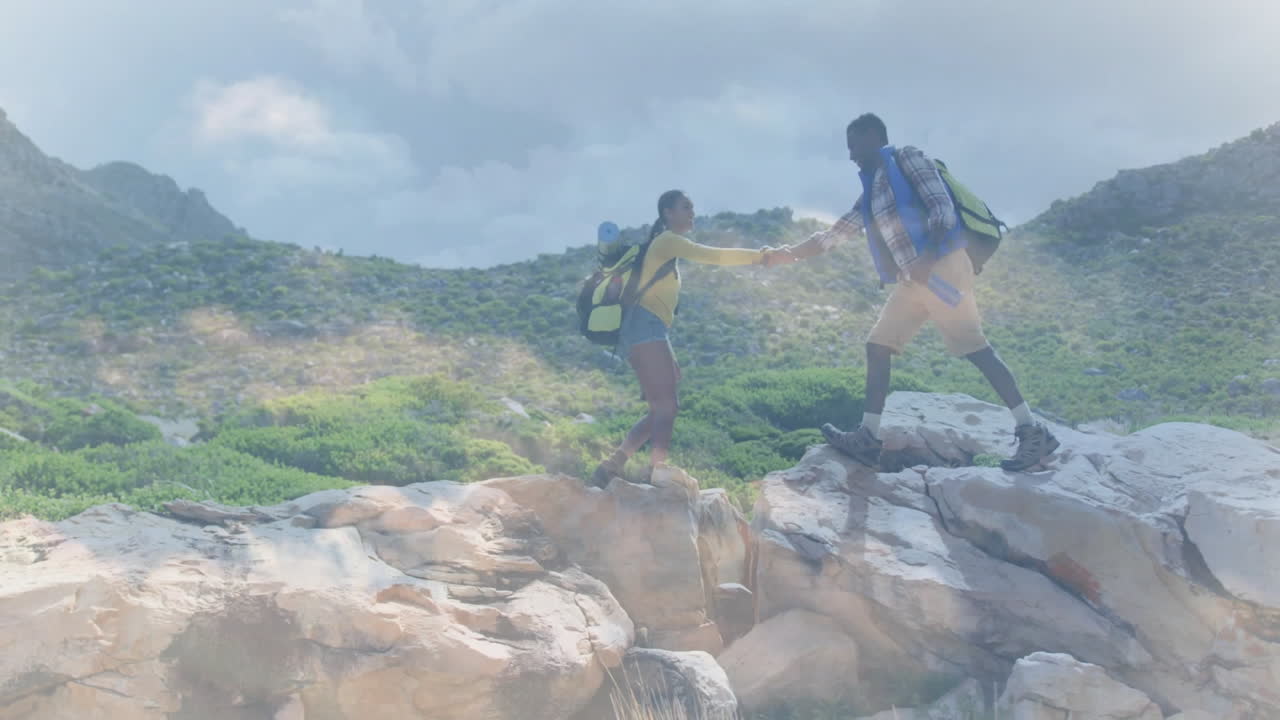 man helping woman climbing rocky ledge, with floating heart icon and health analytics chart